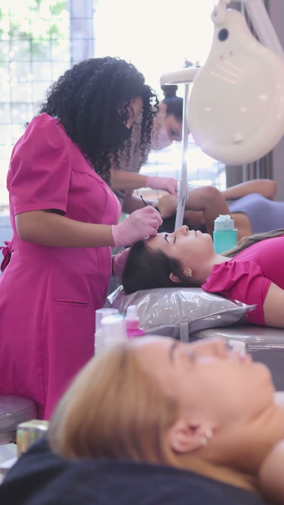 Profissional da Clínica da Barbe atendendo uma cliente deitada na maca